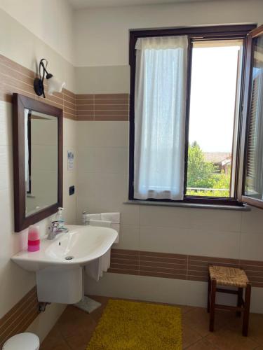 baño con lavabo y ventana en Agriturismo Le Viole, en Barolo