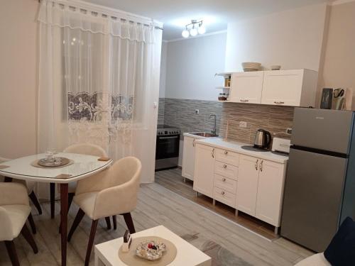 a small kitchen with a table and a refrigerator at Red Square Apartment in Pirot