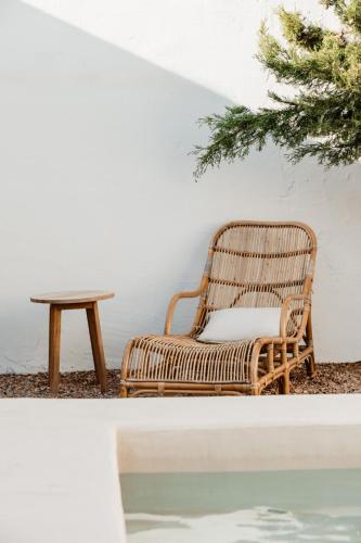 a rattan chair sitting next to a table at Aguamadera in Santa Eularia des Riu