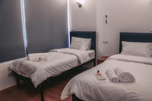 a room with two beds with towels and a mirror at Apple cozy hotel in Tbilisi City
