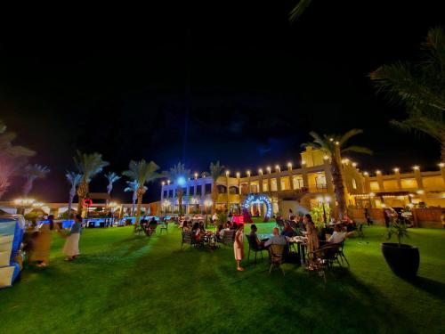 a group of people sitting in a park at night at Qasr alnkheel resort and hotel in Jericho