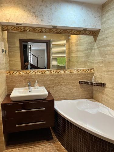 a bathroom with a tub and a sink and a mirror at Apartament w Ostródzie in Ostróda