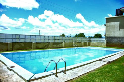 a large swimming pool with blue water in a yard at Jacky's Milimani suites in Nakuru