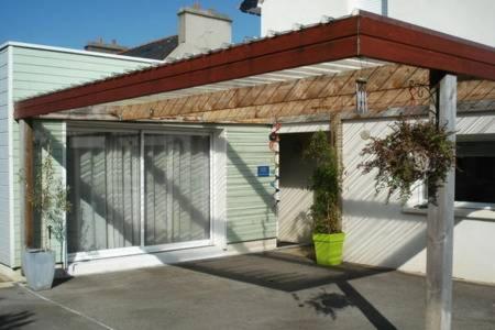 a house with a garage with a door at Petit studio - Chambre indépendante au calme in Landerneau