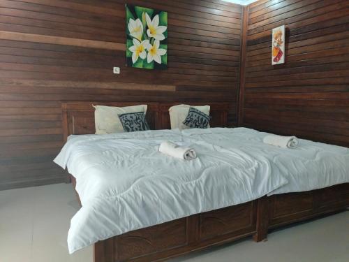 een slaapkamer met een bed met twee handdoeken erop bij PENIDA MEMORIES COTTAGE in Batununggul