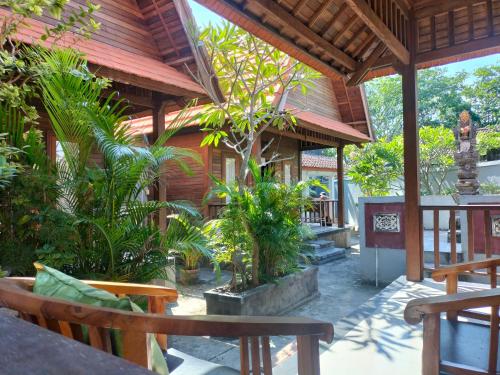 een patio van een huis met bomen en planten bij PENIDA MEMORIES COTTAGE in Batununggul