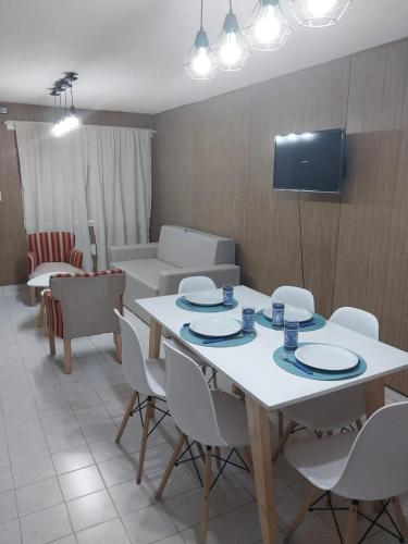 a dining room with a white table and white chairs at Tu Casita de Paso in General Acha