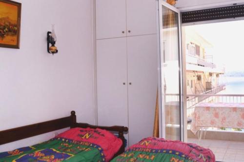 a bedroom with a bed and a large window at Unique & cozy seaview apartment. in Loutraki