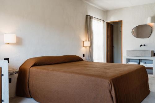 a bedroom with a bed with a brown blanket on it at Aguamadera in Santa Eularia des Riu