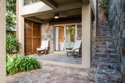 a patio with two chairs on a house at Beautiful 3 story 8,000 sq ft Oceanside Mansion in Nevis