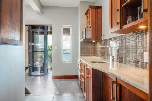 a kitchen with wooden cabinets and a glass door at Beautiful 3 story 8,000 sq ft Oceanside Mansion in Nevis
