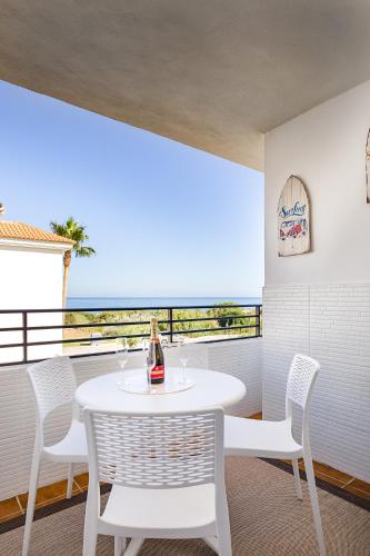 a white table and chairs on a balcony with the ocean at Relax at Premium Beach flat - Aldea Beach in Manilva