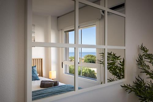 a mirror in a room with a bed and a window at Relax at Premium Beach flat - Aldea Beach in Manilva