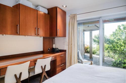 a kitchen with wooden cabinets and a table and chairs at Beautiful 3 story 8,000 sq ft Oceanside Mansion in Nevis