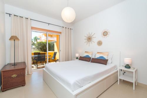 um quarto branco com uma cama grande e uma varanda em Casa Nobre 2BDR Apartment w Pool & Patio em Conceição