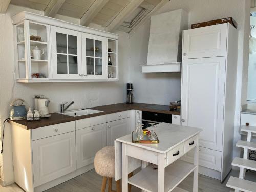 a kitchen with white cabinets and a table in it at Les coeurs brisés in Crans-Montana