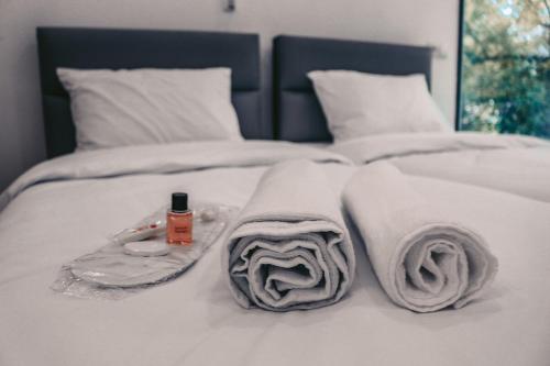 a white bed with towels and a bottle on it at Apple cozy hotel in Tbilisi City