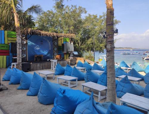 a group of blue pillows and tables on a beach at Gili Mesari Cottages & Homestay in Gili Trawangan
