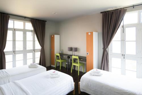 En eller flere senge i et værelse på Dorm of Happiness by Tharaburi Resort