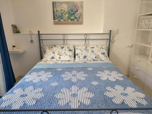 a bedroom with a bed with a blue and white bedspread at La Casetta in Montesilvano