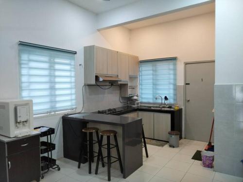 a kitchen with a sink and a counter with stools at Malay Homestay di Meru, Klang in Kapar