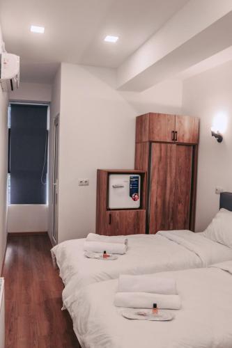 a room with two beds and a tv on the wall at Apple cozy hotel in Tbilisi City
