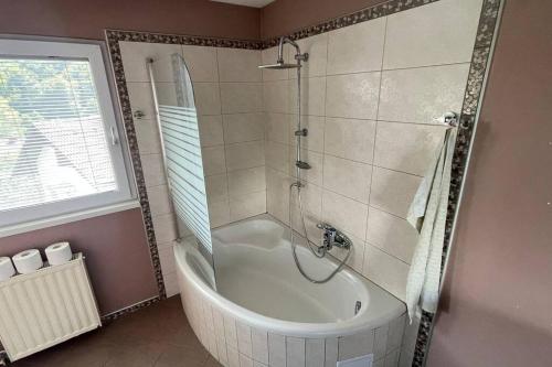 La salle de bains est pourvue d'une baignoire et d'une douche. dans l'établissement Family House Simba, à Smarjeske Toplice