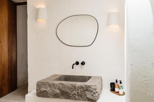 a bathroom with a stone sink and a mirror at Aguamadera in Santa Eularia des Riu