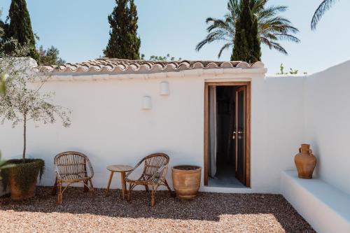 a white house with two chairs and a table at Aguamadera in Santa Eularia des Riu