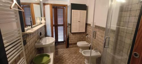 uma casa de banho com 2 WC, um lavatório e um espelho. em Palazzo centro storico em Soriano nel Cimino