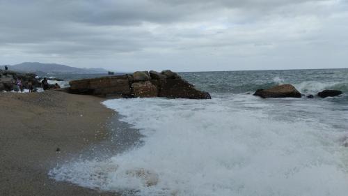 a wave breaking on the shore of a beach at Playa Sant Adrià de Besos in Sant Adria de Besos