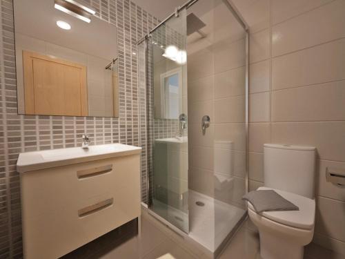 uma casa de banho com um chuveiro, um WC e um lavatório. em Banus Boutique Muelle del Ribera em Marbella