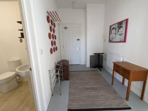 a white bathroom with a toilet and a table at 2-bed in central Margate in Kent