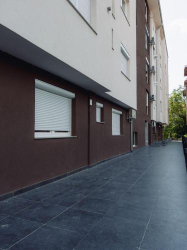 an empty sidewalk next to a building with a window at Darki Apartments 2 - Very Central Stay With Free Parking in Ohrid