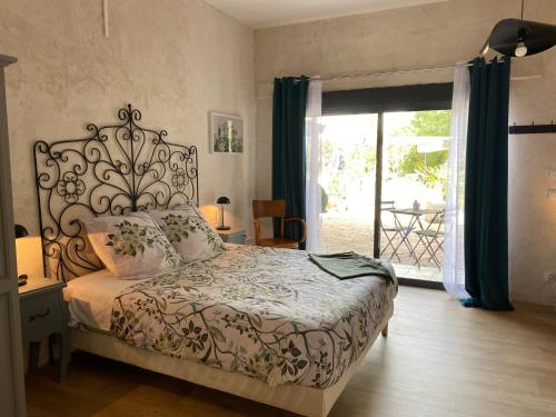 a bedroom with a bed and a sliding glass door at Maison Sur Véranda in Courzieu
