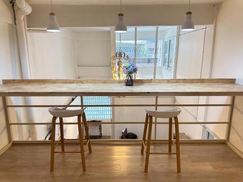 a kitchen with a large counter with two bar stools at Letter Better Home in Ban Bo Sai Klang