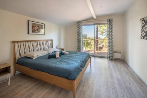 a bedroom with a bed and a large window at Pyla Villa DE LA DUNE promo vacances d'été in La Teste-de-Buch
