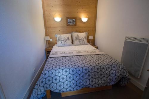 une petite chambre avec un lit avec une couette bleue dans l'établissement Tignes - Résidence Le Borsat au pied des pistes (4 personnes), à Tignes