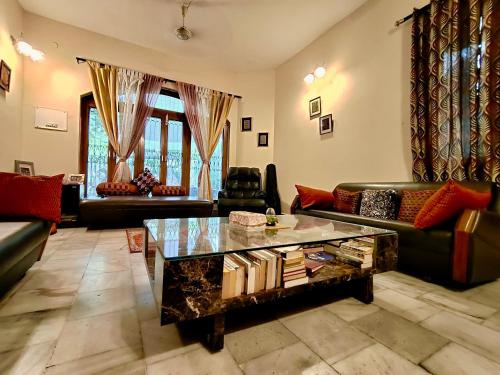 a living room with couches and a coffee table at UVs Homestay in Haridwār