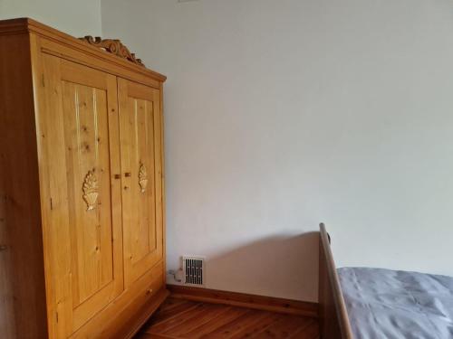 a bedroom with a wooden cabinet next to a bed at Artapartamenty in Rzeszów
