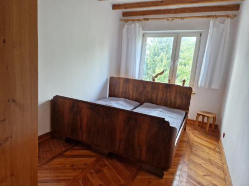 a large wooden bed in a room with a window at Artapartamenty in Rzeszów