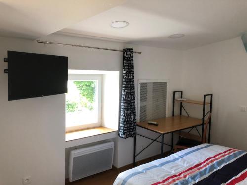 a bedroom with a bed and a window and a desk at maison blanche in Eymet