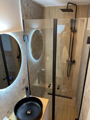 a bathroom with a sink and a shower with a mirror at Pensiunea Padurea Verde in Moieciu de Sus