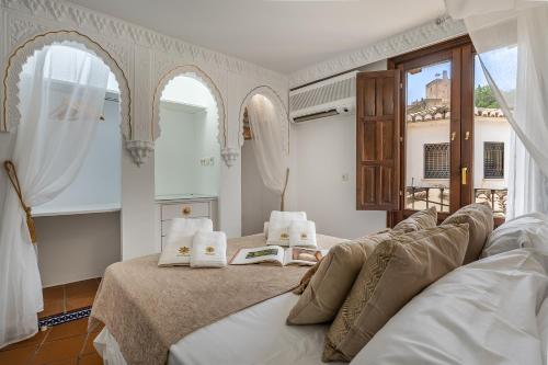 a bedroom with two beds and two windows at ADANAR-Apartamentos Muralla Zirí in Granada