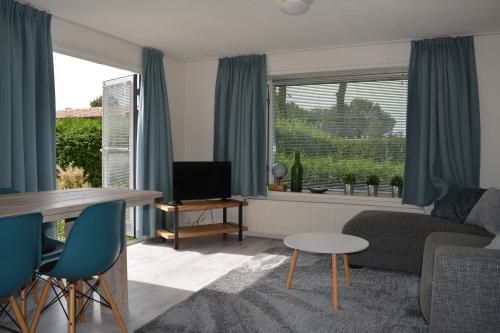 uma sala de estar com um sofá e uma mesa em Veluwe chalet em Putten