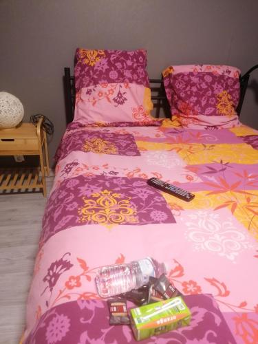 1 dormitorio con 2 camas con sábanas rosas y moradas en Chambres dans maison familiale, en Saint-Girons