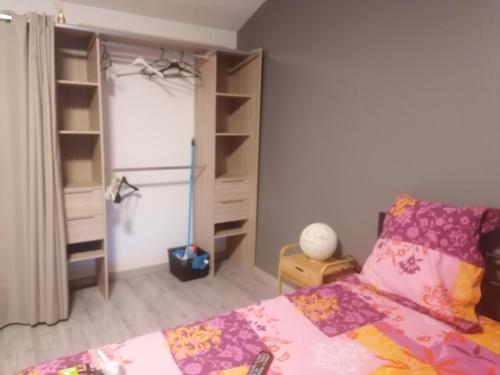 - une chambre avec un lit et une étagère dans l'établissement Chambres dans maison familiale, à Saint-Girons