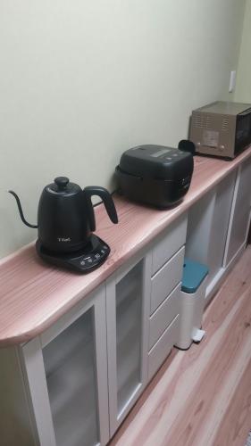 a counter with a table with a tea pot on it at 民泊のらりくらり in Ajima