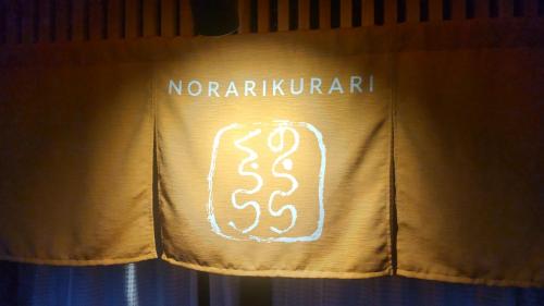 a neon sign on a curtain with the wordsnoraugh istg at 民泊のらりくらり in Ajima