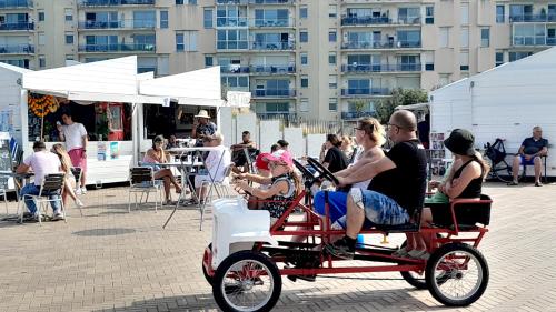 a group of people riding on a pedal bike at Studio plage, vue mer et dragon, garage pour moto in Calais